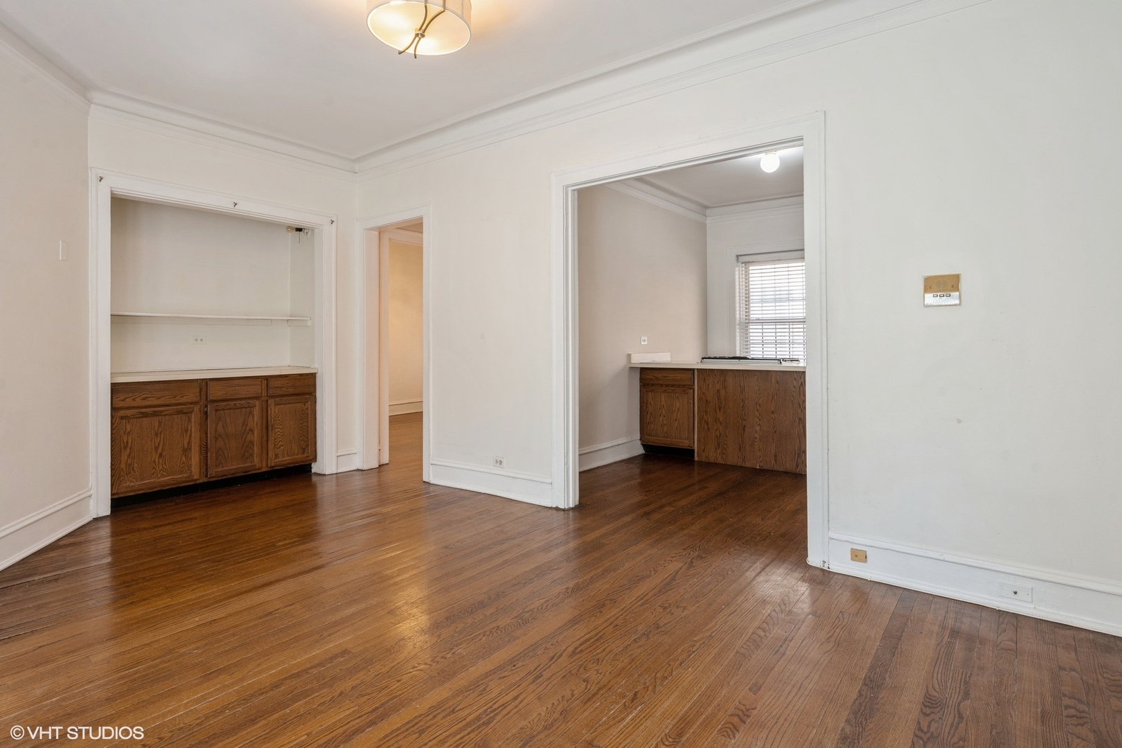 538 West Brompton Avenue, Unit 1W Chicago, IL 60657 - Photo 5 of 16 an empty room with wooden floor and cabinet