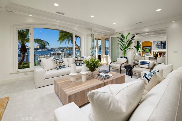a living room with furniture kitchen view and a large window