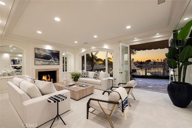 a living room with furniture a fireplace and a floor to ceiling window