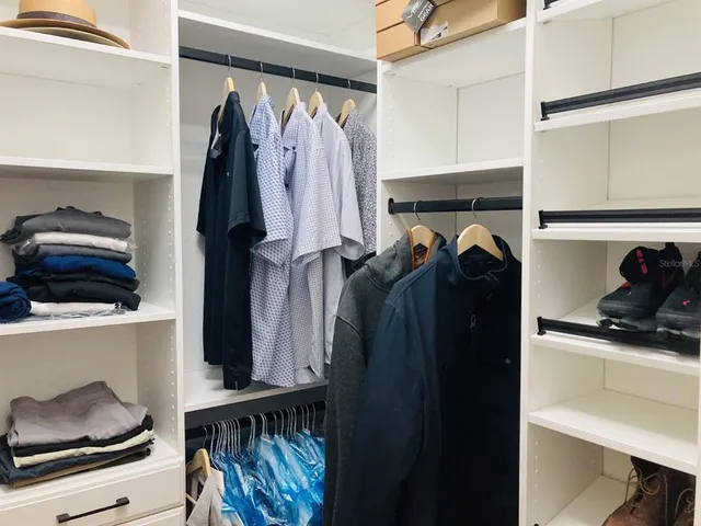 a view of walk in closet with clothes and shoes