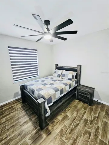 a bedroom with a bed and wooden floor