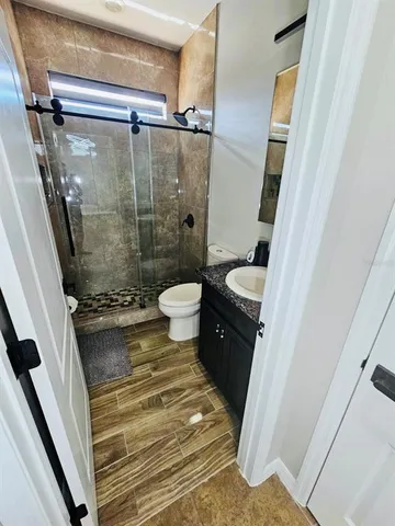 a bathroom with a granite countertop sink toilet and shower
