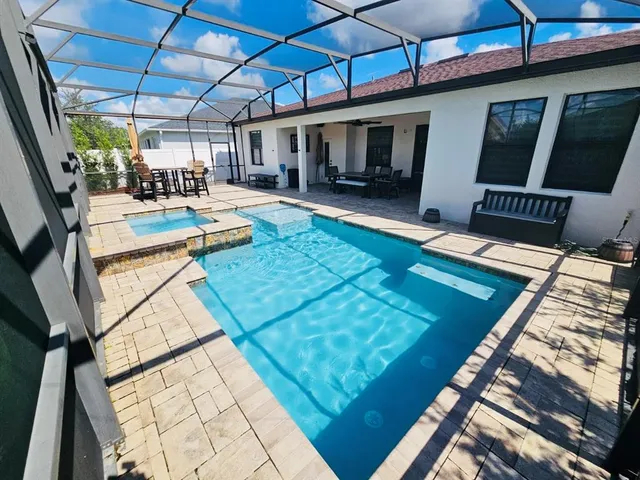 a view of a patio with table and chairs with wooden floor and fence