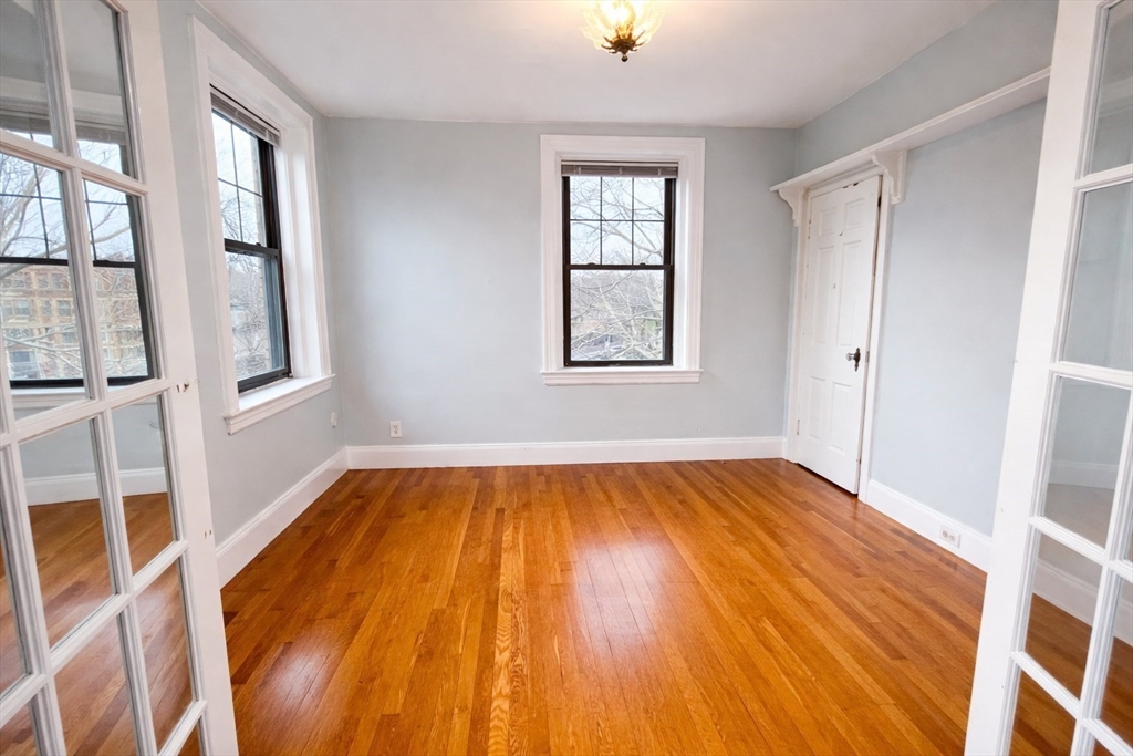 10 Jamaicaway, Unit 23 Boston, MA 02130 - Photo 12 of 14 an empty room with wooden floor and windows