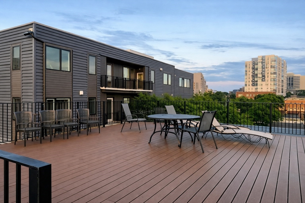 10 Jamaicaway, Unit 23 Boston, MA 02130 - Photo 3 of 14 a roof deck with table and chairs