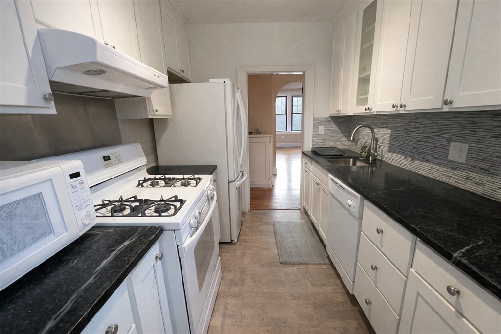 10 Jamaicaway, Unit 23 Boston, MA 02130 - Photo 6 of 14 a kitchen with stainless steel appliances a stove a sink and a refrigerator