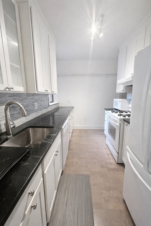 10 Jamaicaway, Unit 23 Boston, MA 02130 - Photo 7 of 14 a kitchen with a sink stove top oven and cabinets