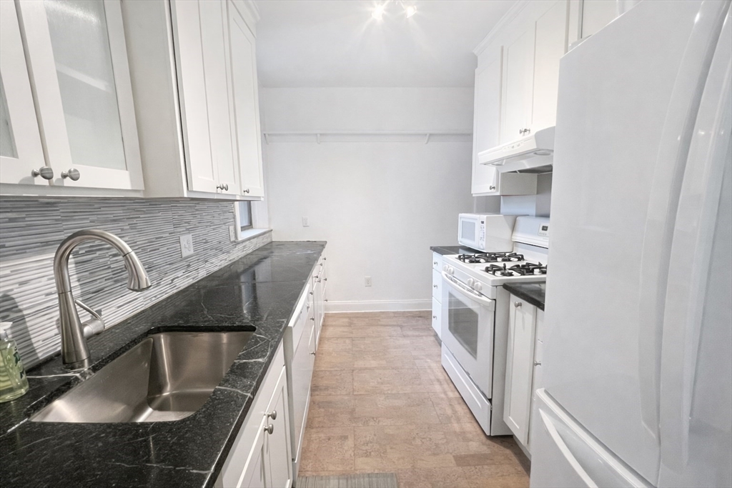 10 Jamaicaway, Unit 23 Boston, MA 02130 - Photo 8 of 14 a kitchen with granite countertop a sink a stove and refrigerator