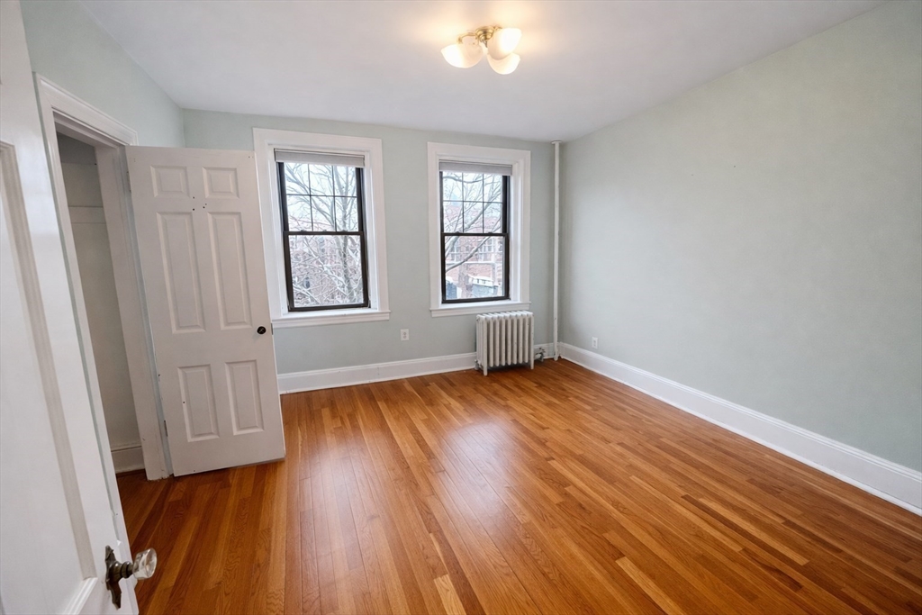 10 Jamaicaway, Unit 23 Boston, MA 02130 - Photo 9 of 14 an empty room with wooden floor and windows