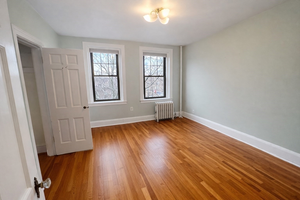 10 Jamaicaway, Unit 23 Boston, MA 02130 - Photo 10 of 14 an empty room with wooden floor and windows