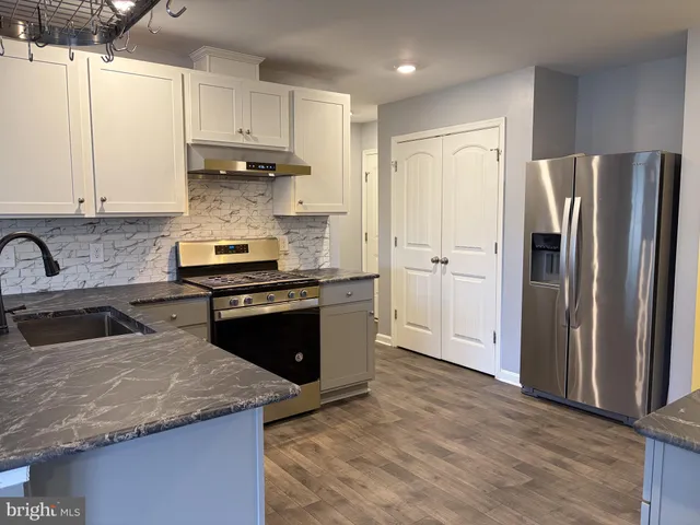 a kitchen with a refrigerator sink and cabinets