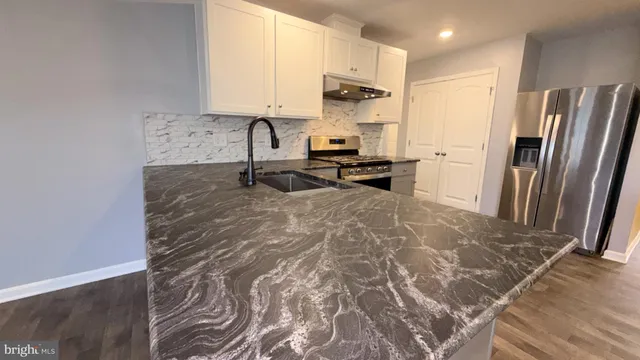 a kitchen with stainless steel appliances a stove a refrigerator and a sink