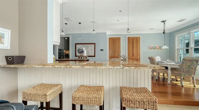 a kitchen with granite countertop a stove and white cabinets