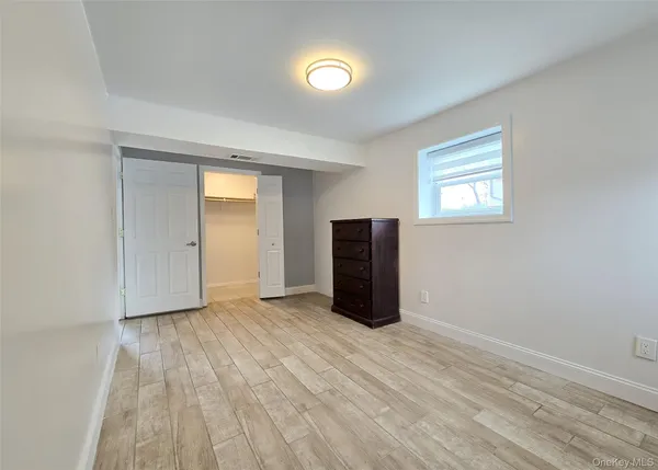 a view of an empty room with closet and a window