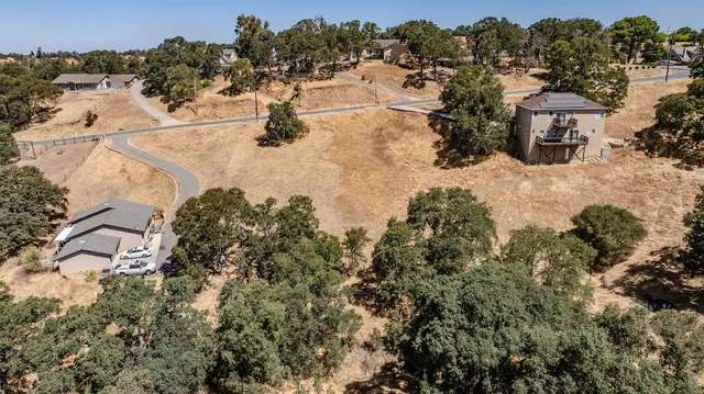 an aerial view of a house with a yard and mountain view in back