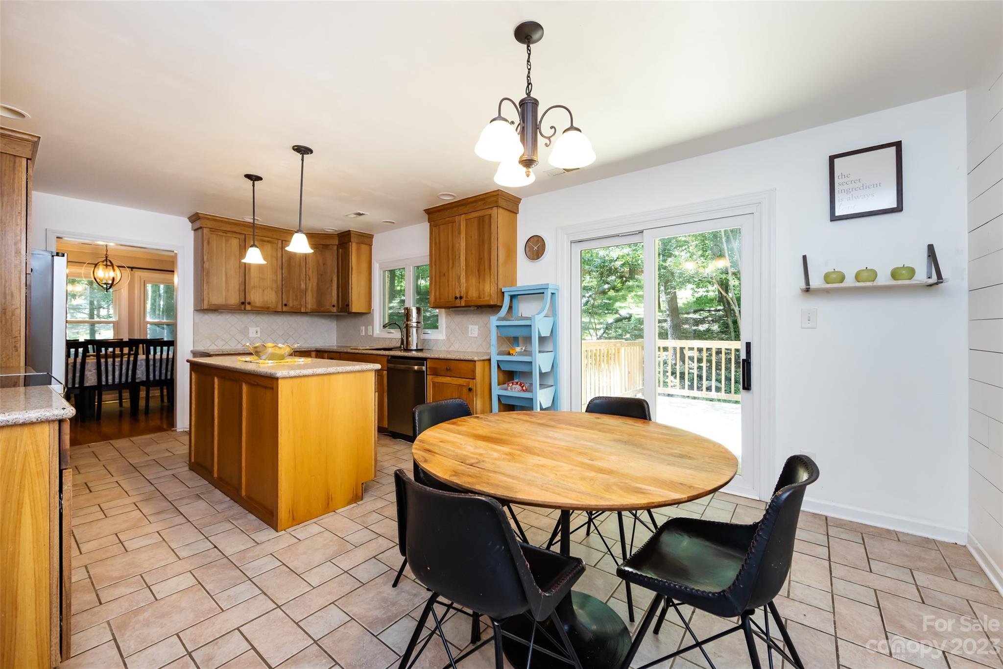 9441 Man O War Road Indian Land, SC 29707 - Photo 22 of 45 a kitchen with stainless steel appliances granite countertop a stove a refrigerator a kitchen island a dining table and chairs with wooden floor