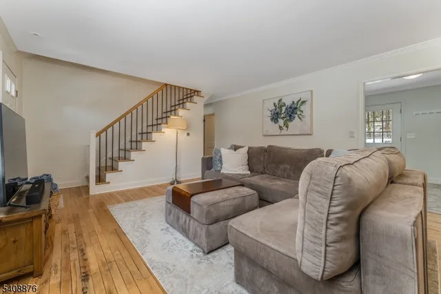 a living room with a bed and wooden floor
