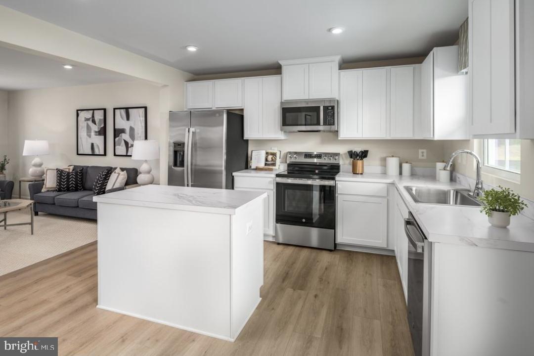 1180 West Walnut Road, Unit 9 Vineland, NJ 08360 - Photo 3 of 17 a kitchen with stainless steel appliances granite countertop a stove top oven a sink a refrigerator white cabinets and wooden floor