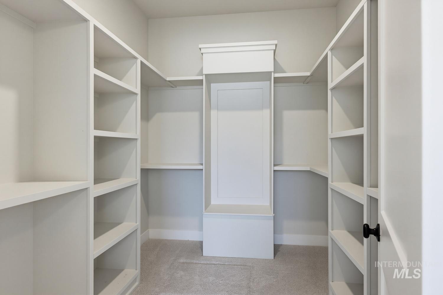 5054 Heritage Drive Marsing, ID 83639 - Photo 27 of 38 Custom closet system featuring extensive built-in shelving, integrated center storage with seating, and light-colored carpeting