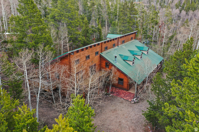 Log-style exterior construction with a green metal roof and multiple dormer windows