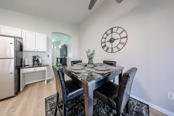 a view of a dining room with furniture and a refrigerator