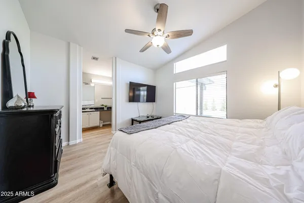 a spacious bedroom with a bed and a flat screen tv