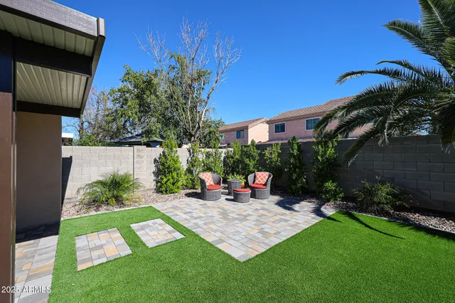 a view of a chair and table in backyard of the house