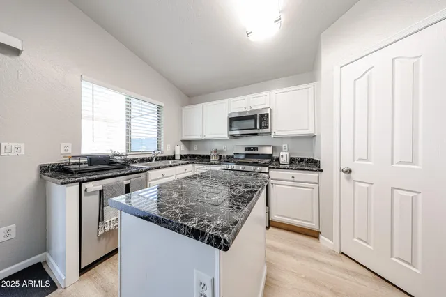 a kitchen with stainless steel appliances a sink stove and microwave