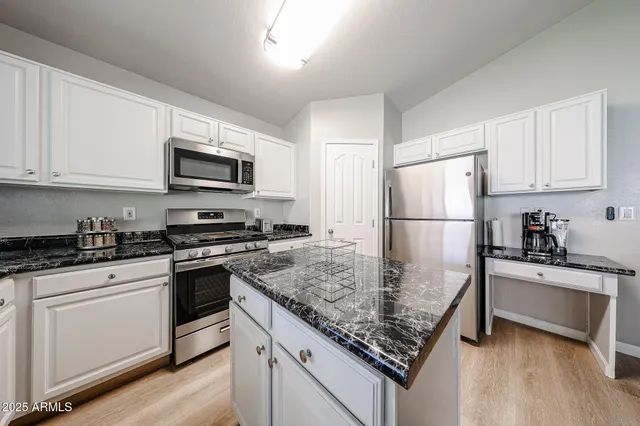 a kitchen with kitchen island a sink stainless steel appliances and counter space