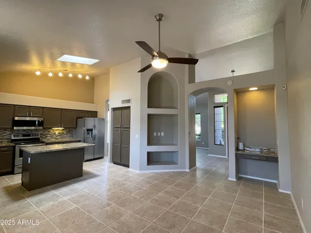 a kitchen with stainless steel appliances granite countertop a stove refrigerator and cabinets