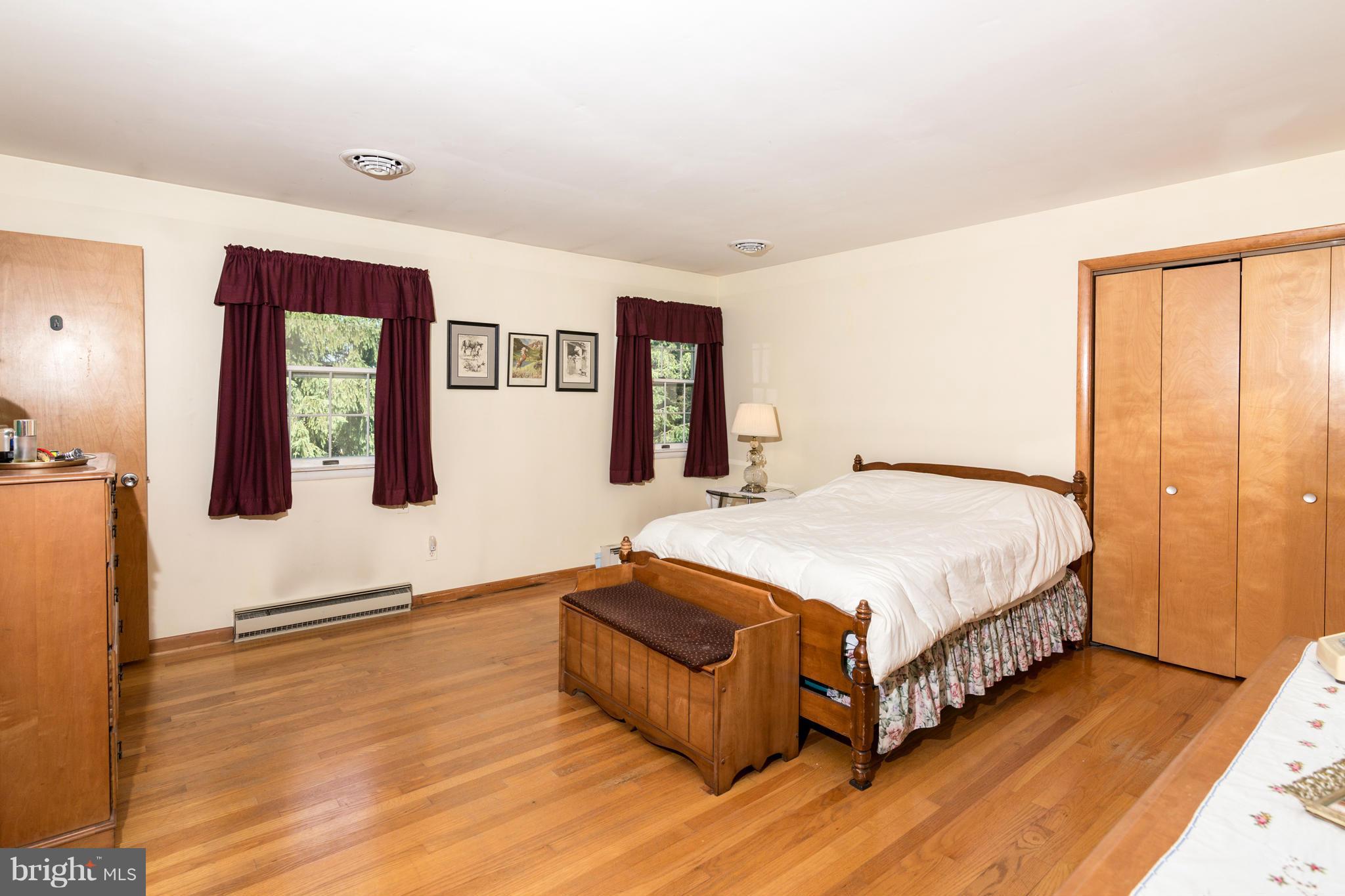 7227 Morgan Road Woodbine, MD 21797 - Photo 9 of 29 a spacious bedroom with a bed and dresser with wooden floor