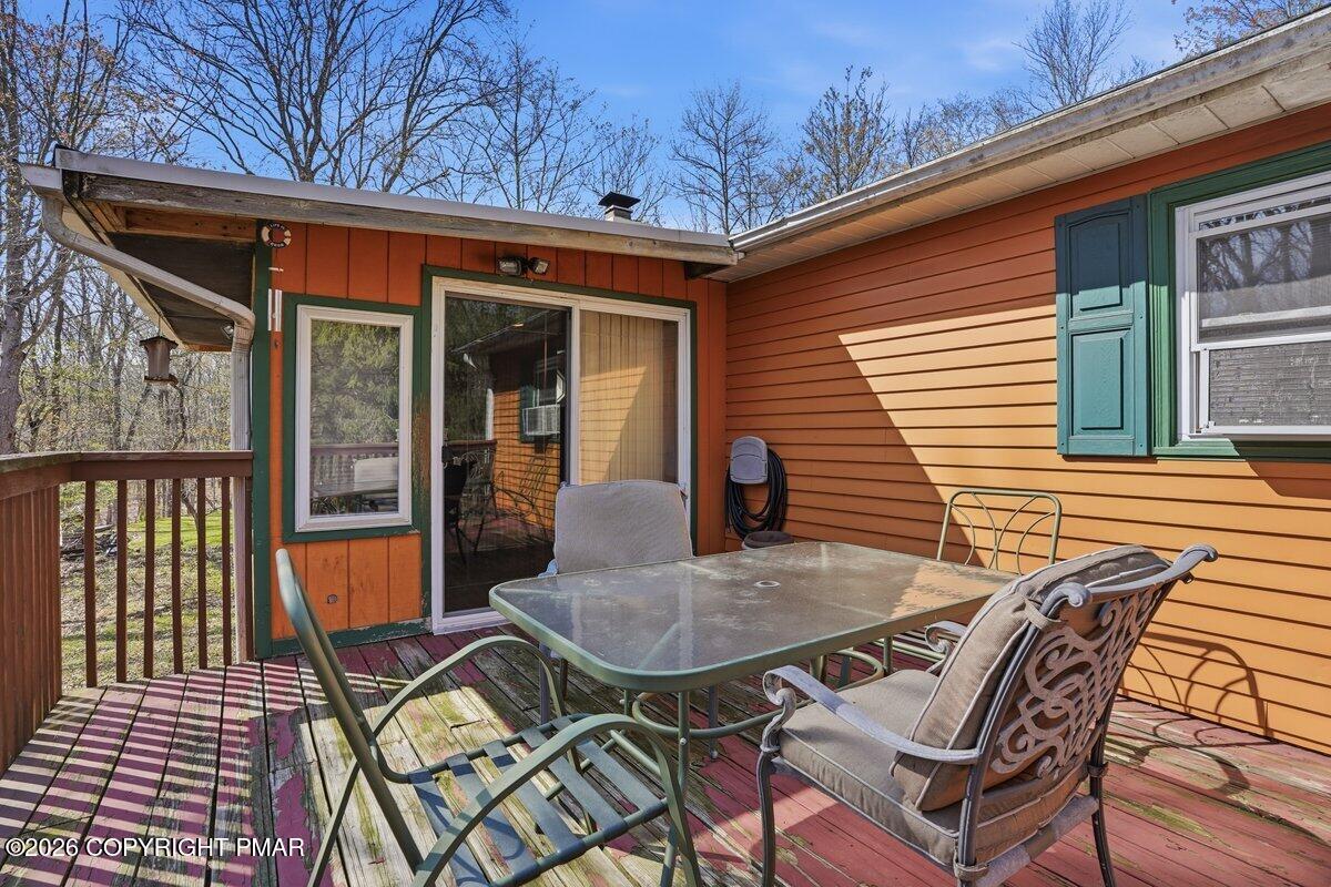 3116 Woodland Court Bushkill, PA 18324 - Photo 51 of 72 a view of a patio with table and chairs with wooden floor and fence
