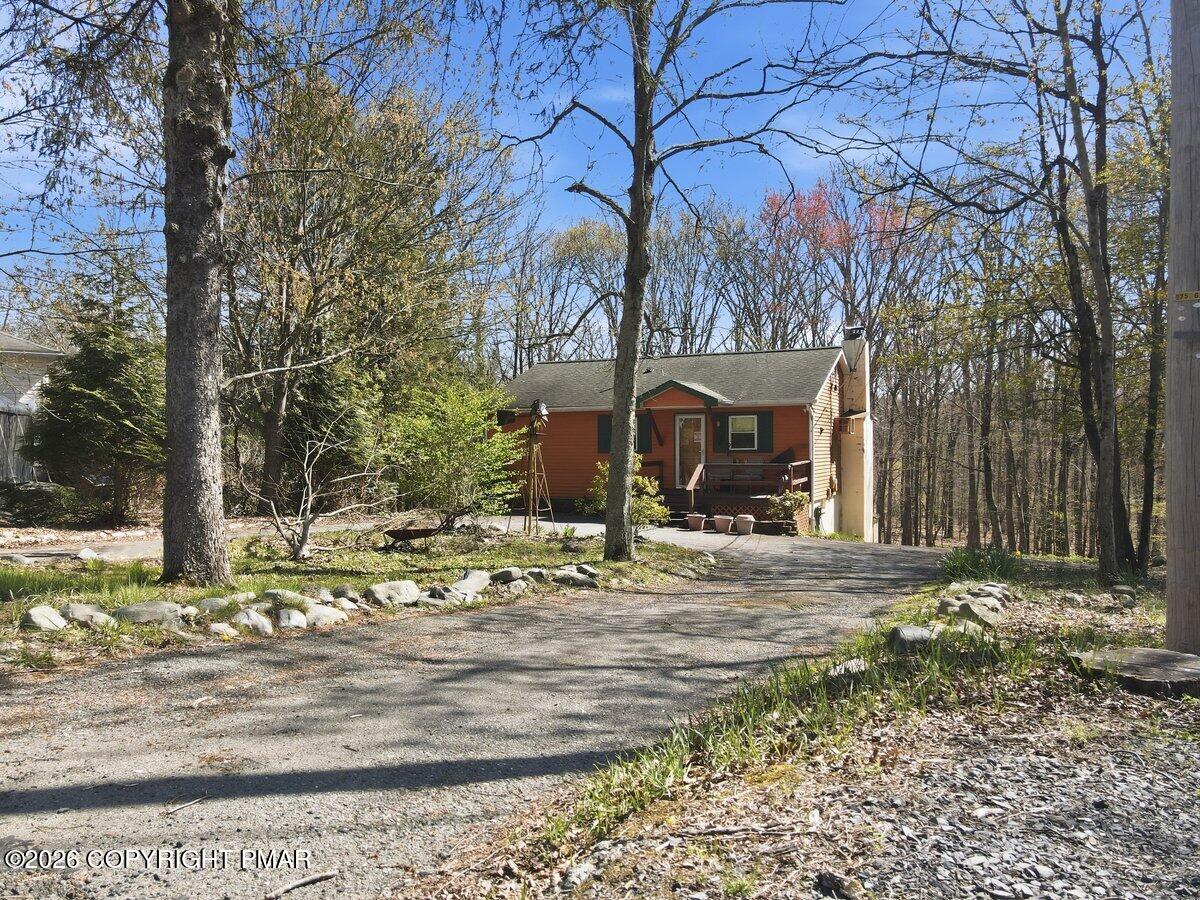 3116 Woodland Court Bushkill, PA 18324 - Photo 53 of 72 a front view of a house with trees and flowers