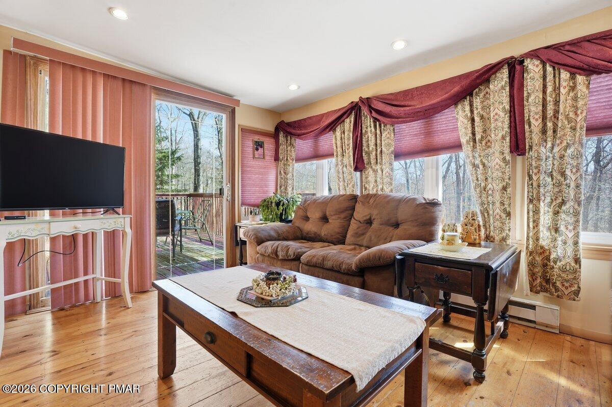 3116 Woodland Court Bushkill, PA 18324 - Photo 6 of 72 a living room with furniture a flat screen tv and a floor to ceiling window