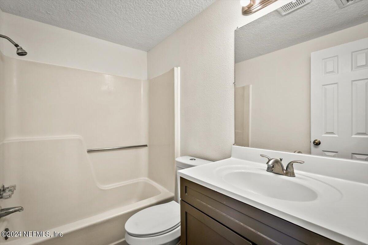 8264 Devoe Street Jacksonville, FL 32220 - Photo 13 of 24 a bathroom with a granite countertop sink toilet and shower