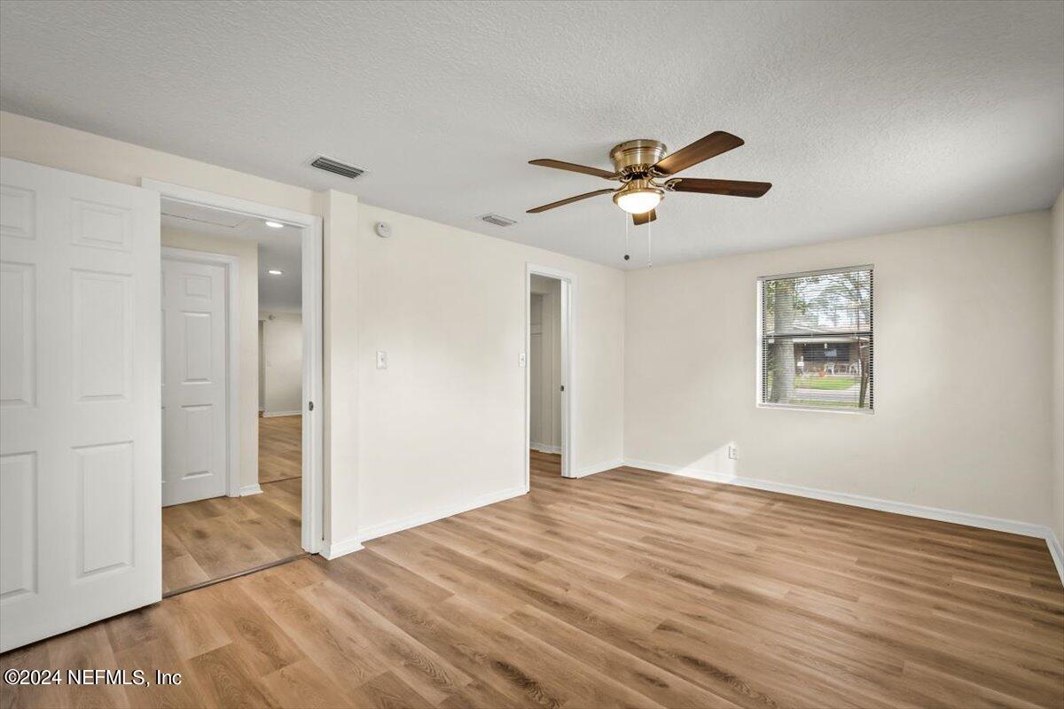 8264 Devoe Street Jacksonville, FL 32220 - Photo 15 of 24 a view of a bedroom with a bed and a chandelier fan