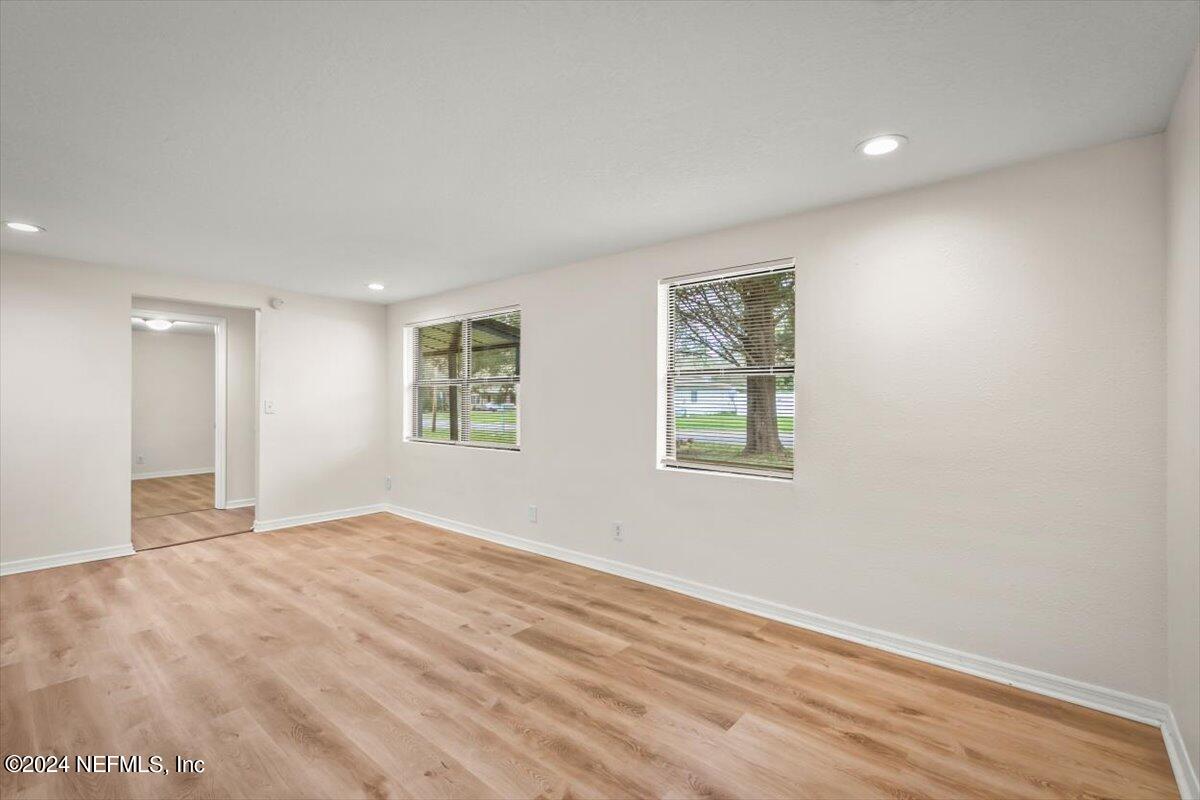 8264 Devoe Street Jacksonville, FL 32220 - Photo 4 of 24 a view of an empty room with wooden floor and a window