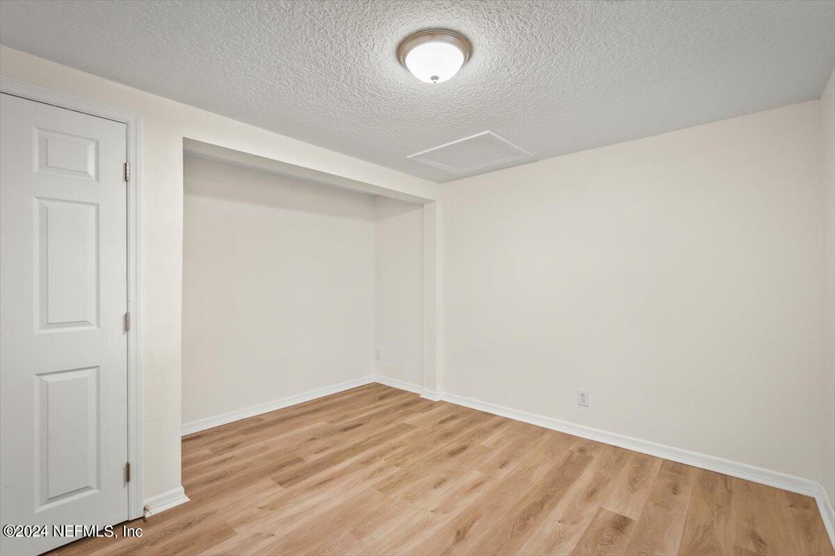 8264 Devoe Street Jacksonville, FL 32220 - Photo 10 of 24 an empty room with wooden floor and windows