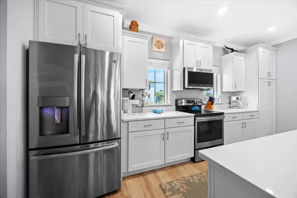 a kitchen that has a lot of cabinets a refrigerator and a stove