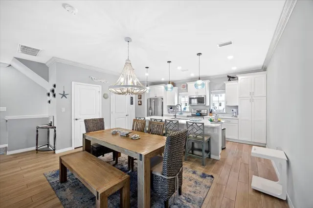 a dining room with stainless steel appliances kitchen island granite countertop a table and chairs