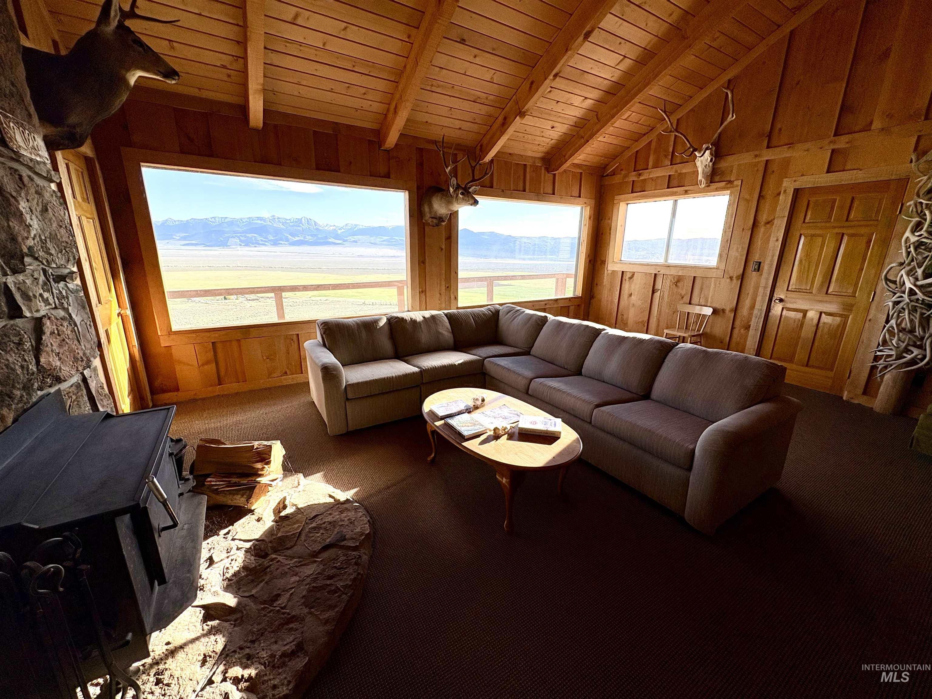 2040 Pahsimeroi River Road May, ID 83253 - Photo 12 of 29 Living space featuring extensive wood paneling and exposed beam ceiling