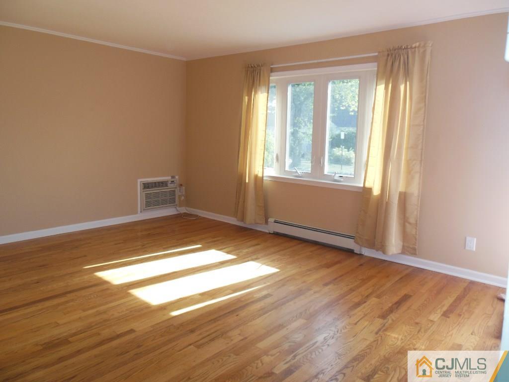 514 Fairway Road Linden, NJ 07036 - Photo 2 of 16 an empty room with wooden floor and windows