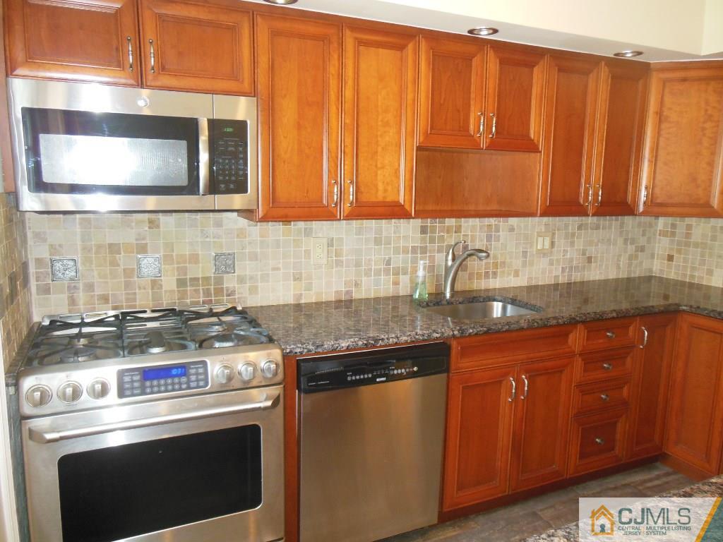514 Fairway Road Linden, NJ 07036 - Photo 5 of 16 a kitchen with granite countertop wood cabinets stainless steel appliances and a sink