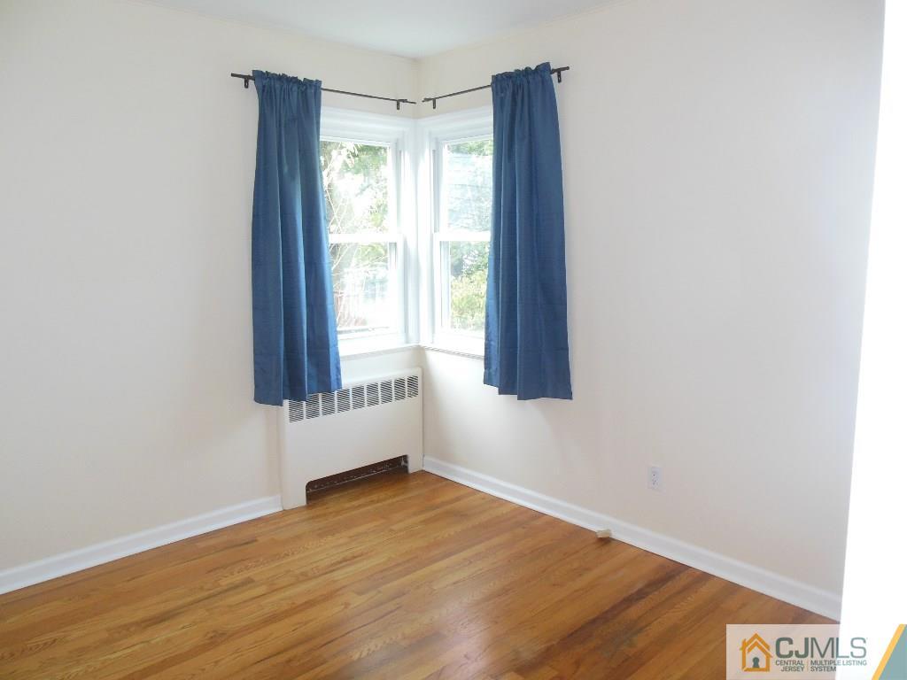 514 Fairway Road Linden, NJ 07036 - Photo 7 of 16 a view of an empty room with wooden floor and a window