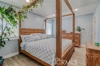 a bedroom with a large bed and a potted plant
