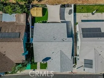 an aerial view of residential houses with outdoor space and parking
