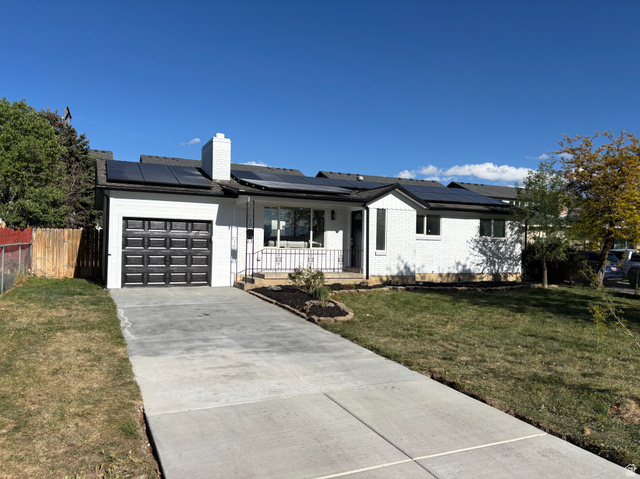 6709 South 230 East Midvale, UT 84047 - Photo 1 of 1 Ranch-style home with a porch, brick siding, driveway, a garage, and solar panels