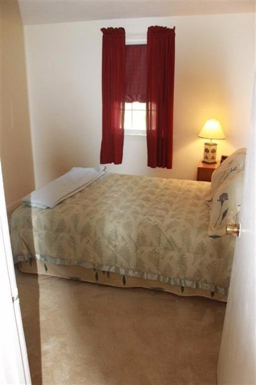 1344 Shootflying Hill Road Centerville, MA 02632 - Photo 13 of 18 a bed sitting in a bedroom next to a window