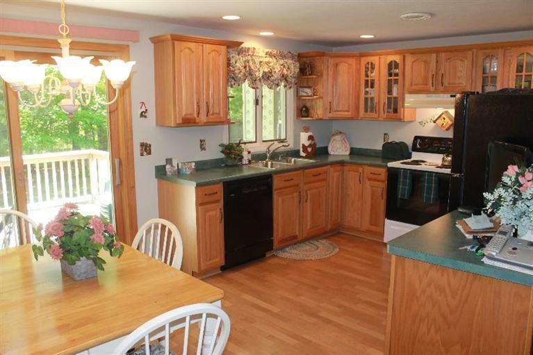 1344 Shootflying Hill Road Centerville, MA 02632 - Photo 4 of 18 a kitchen with stainless steel appliances granite countertop a refrigerator a stove top oven a sink dishwasher and wooden cabinets
