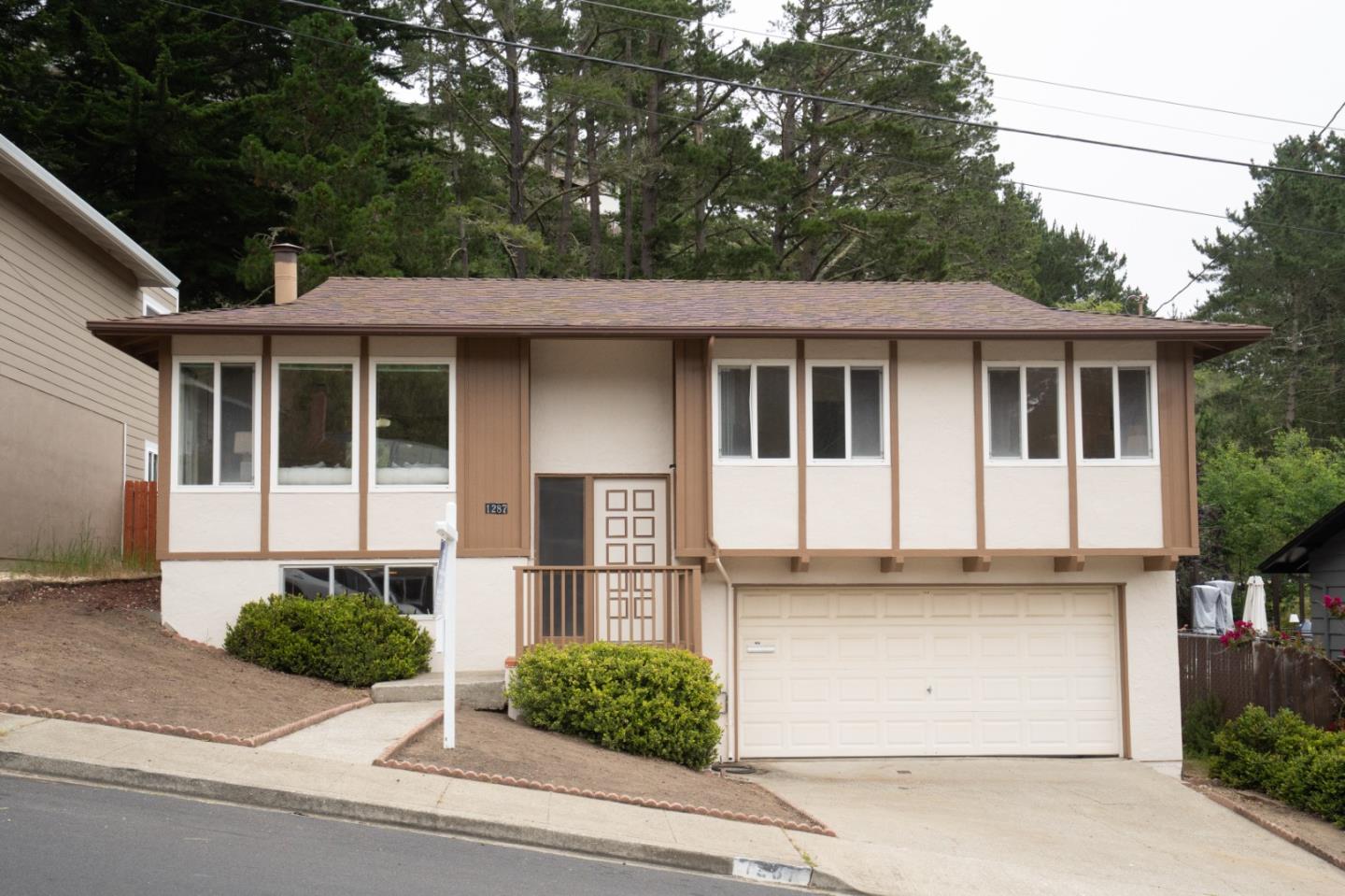 1287 Lerida Way Pacifica, CA 94044 - Photo 1 of 52 a front view of a house with garage and plants